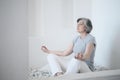 An elderly fit woman practicing yoga and meditation in an attempt to achieve harmony and balance