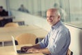 Elderly gentleman makes funny faces using a laptop Royalty Free Stock Photo