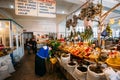 Elderly Georgian Woman Seller Sorting Herbs Near Abundant Counter