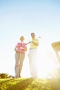 Elderly golfers. Attractive elderly couple on the green with the sun setting behind them. Royalty Free Stock Photo