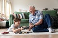 Elderly grandfather giving present to smiling grandson. Royalty Free Stock Photo