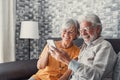 Elderly grandfather and grandmother spend time having fun using smartphone apps, middle-aged wife enjoy online entertainments, Royalty Free Stock Photo