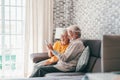 Elderly grandfather and grandmother spend time having fun using smartphone apps, middle-aged wife enjoy online entertainments, Royalty Free Stock Photo