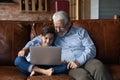 Elderly grandfather and small grandson use laptop Royalty Free Stock Photo