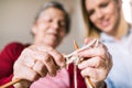 Elderly grandmother and adult granddaughter at home, knitting.