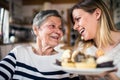 An elderly grandmother with an adult granddaughter at home.