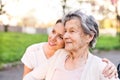 Elderly grandmother and granddaughter hugging in spring nature. Royalty Free Stock Photo