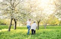 Elderly grandmother with crutch and granddaughter in spring nature.