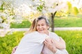 Elderly grandmother and granddaughter hugging in spring nature. Royalty Free Stock Photo