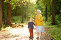 Elderly grandmother and her little grandchild walking together in sunny summer park. Grandma and grandson Royalty Free Stock Photo