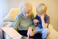 Elderly grandmother and little grandchild looking family photos album. Grandma and grandson Royalty Free Stock Photo