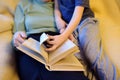 Elderly grandmother and little grandchild reading a book at home. Grandma and grandson