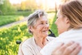 Elderly grandmother in wheelchair with granddaughter in spring nature. Royalty Free Stock Photo