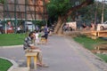 Elderly gray-bearded man with shaggy hair is sitting on a bench. Pensive tired man