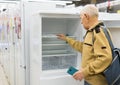 elderly man choosing refrigerator in showroom of electrical appliance store Royalty Free Stock Photo