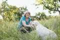 Elderly grayhaired woman with her dog in the park