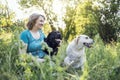 Elderly grayhaired woman with her dogs in the park. Portrait of a smiling senior female sitting with her golden and black Royalty Free Stock Photo