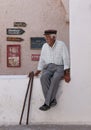 Elderly Greek man sitting in a low wall