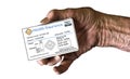 An elderly hand holds a medical insurance ID card to illustrate healthcare