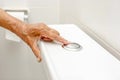 Elderly Hand Pressing Toilet Flush Button Royalty Free Stock Photo