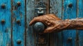 Elderly hand on rustic blue door knob Royalty Free Stock Photo