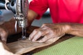 Elderly hand with a sewing machine.