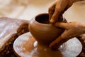 Elderly hands of a potter, creating an earthen jar on the circle. Old woman makes hand made ceramics from clay Royalty Free Stock Photo