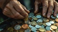 Elderly hands sorting a collection of various coins in different sizes and colors Royalty Free Stock Photo