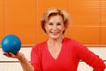 Elderly happy woman holding a blue gymnastic ball Royalty Free Stock Photo