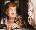 An elderly happy woman is looking out the window. Royalty Free Stock Photo