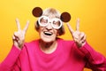 Elderly happy woman showing victory sign and looking at the camera Royalty Free Stock Photo