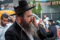 An elderly Hasid in traditional Jewish hat talking on the phone