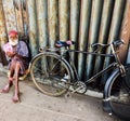 Elderly hindu cyclist resting on the street with his bicycle