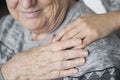 Elderly holding a hand on the shoulder