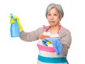 Elderly housewife hold with bottle spray and rag Royalty Free Stock Photo