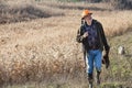 Elderly hunter with wild bird in orange hat Royalty Free Stock Photo