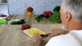 Elderly husband cutting vegetables, cooking dinner at home, health care, hobby