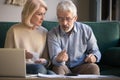 Elderly husband and wife calculate finances paying bills online