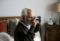 An elderly Indian man at the retirement house taking a photo Royalty Free Stock Photo