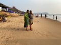 An elderly Indian man and woman standing on a beach and having a conversation