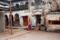 Elderly Indian woman sits alone inside the yard