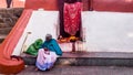 An elderly Indian woman sitting beside a shrine in the ancient Hindu Kamakhya temple