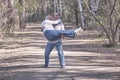 Elderly interracial couple in casual clothes in a spring forest park. A man holding a woman in his arms Royalty Free Stock Photo