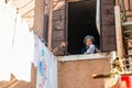 Elderly Italian woman hanging out clothes