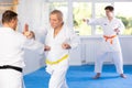 Elderly karate fighter engaging kumite with male rival Royalty Free Stock Photo