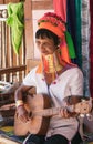 Elderly Kayan woman with a guitar.