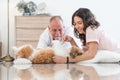 Elderly kind father with beautiful teenage daughter playing with shih tzu puppy dog at home. Caucasian family lying on floor Royalty Free Stock Photo