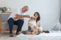 Elderly kind father with his beautiful teenage daughter playing with shih tzu puppy dog at home. Cute Caucasian family having fun Royalty Free Stock Photo