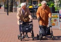 Old ladies wheeled walkers rollator, outdoor street Netherlands