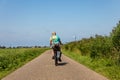 Elderly lady cycling on a dike in Lisse the Netherlands Royalty Free Stock Photo